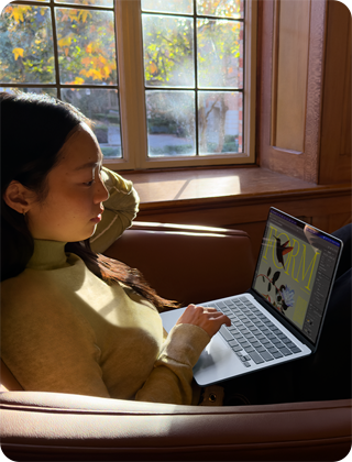 Човек на стол, използващ своя MacBook Air