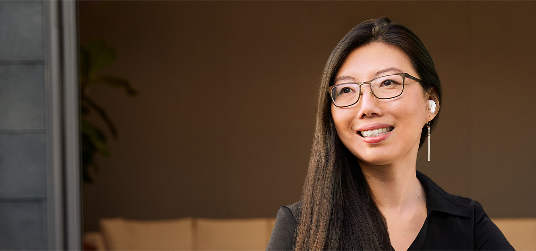 Jessica 坐在戶外，微笑望向右邊，背景是辦公區域。