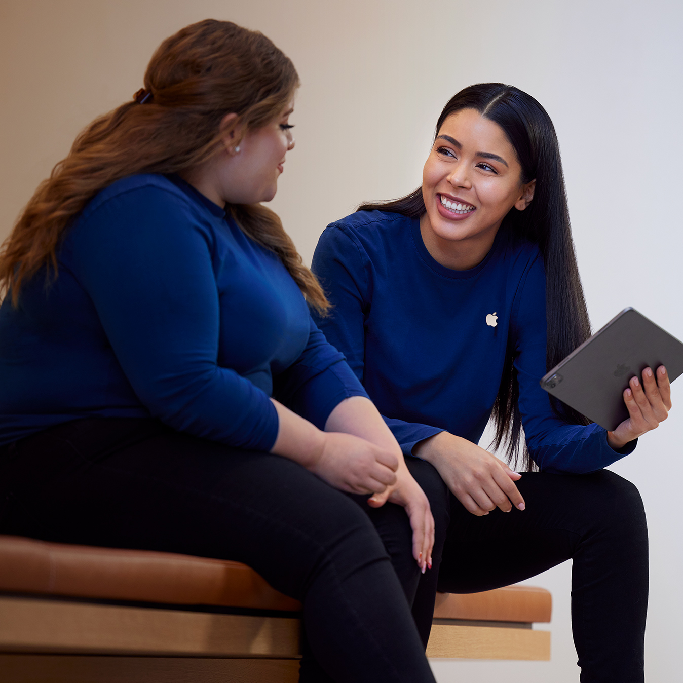 Carissa praat met een iPad in haar hand met een Apple Retail-collega.
