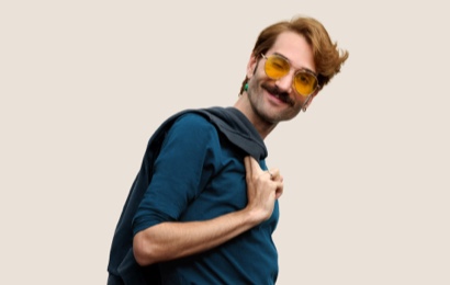 Portret van een glimlachende Apple Retail-medewerker met kort donkerblond haar en een bril.