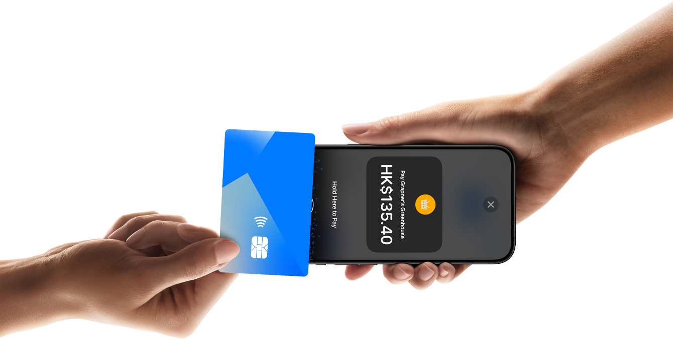 圖片展示一個人手持 iPhone，另一人正用信用卡輕觸該 iPhone，螢幕顯示交易詳情。