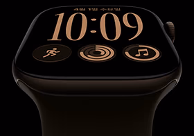 다크 브론즈 색상 알루미늄 케이스의 Apple Watch Series 12. 모듈 시계 페이스에 요일 및 날짜, 운동, 활동 링, Apple Music 컴플리케이션이 표시되어 있고, 오른쪽 옆면 외관의 Digital Crown이 보이는 모습. 올리브 색상 스포츠 밴드를 장착