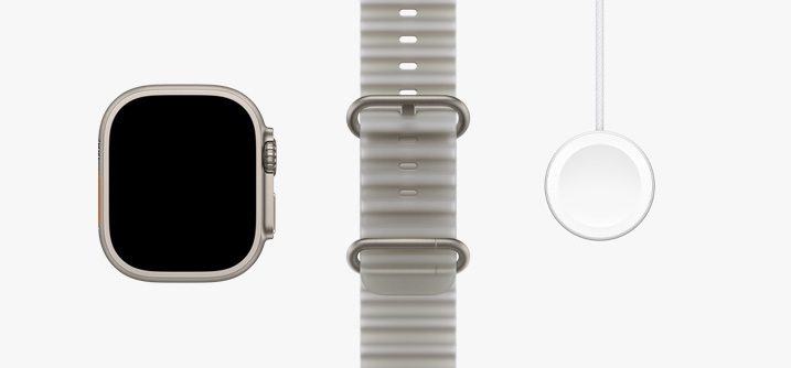 Apple Watch Ultra 4 med urkasse i titanium i farven naturlig, skærm fra kant til kant, Ocean-rem i farven halvtransparent grå og magnetisk Apple Watch-hurtigoplader til USB-C-kabel