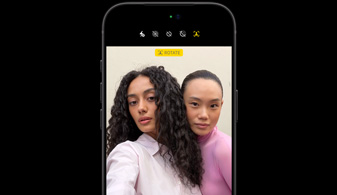 iPhone 18 Pro in Black, front-facing, showcasing two people with face tracking feature, demontration the Center stage front camera feature