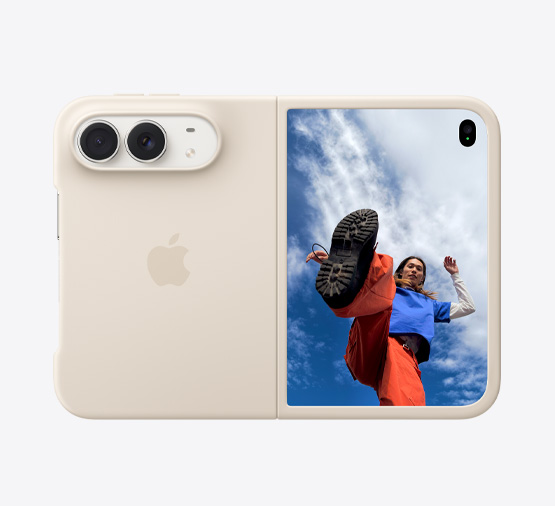 iPhone Duo, Star White colour in Sand Silicone Case, landscape orientation, fully opened horizontally, Dual Fusion cameras on the top left, case covers the back exterior and outer edge of the front display, right side features the outer display with an image of a person standing under a cloud-filled blue sky